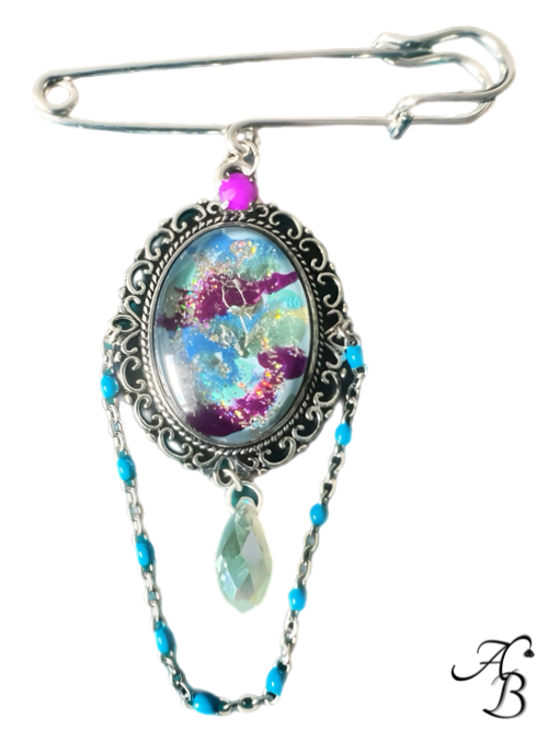 Broche – L’ombre d’une rose, cabochon peint à la main avec reflets violets et chaîne décorative.