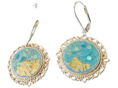 Boucles d’oreilles dormeuses Terre tropicale peintes à la main, cabochon bleu aux reflets holographiques et touches dorées.