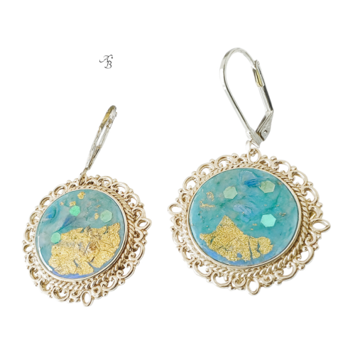 Boucles d’oreilles dormeuses Terre tropicale peintes à la main, cabochon bleu aux reflets holographiques et touches dorées.