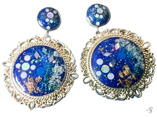 Boucles d’oreilles clous Terre océane avec cabochon rond argenté, paillettes bleues et reflets holographiques faits main.