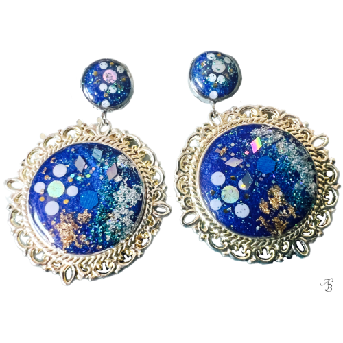 Boucles d’oreilles clous Terre océane avec cabochon rond argenté, paillettes bleues et reflets holographiques faits main.
