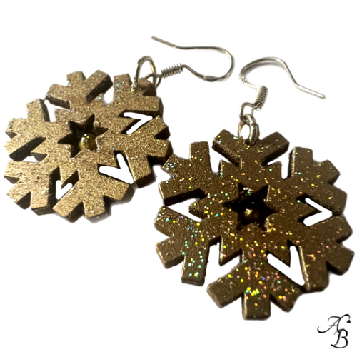 Boucles d’oreilles Flocon doré en bois mordoré avec cristal rouge et paillettes scintillantes, création artisanale Aline B Création.