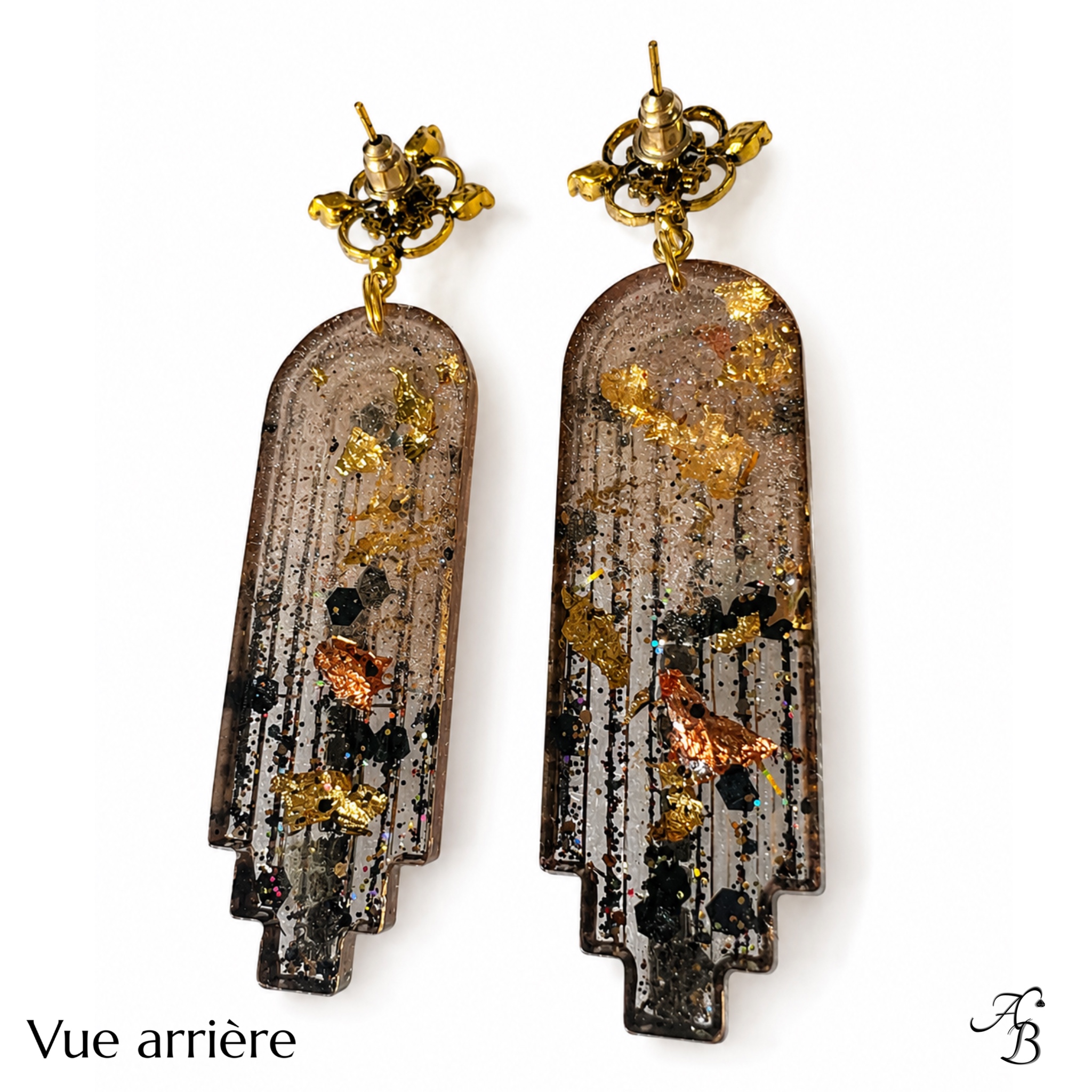 Boucles d’oreilles clous Resin’ Longue dark en résine nervurée avec feuilles métalliques dorées, cuivrées et noires, paillettes dorées et chaînette cristal noir - Aline B Création.