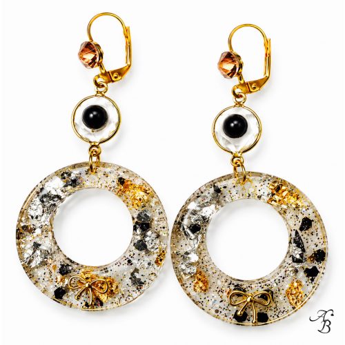 Boucles d’oreilles dormeuses Resin’circle en résine transparente avec feuilles argentées et dorées, paillettes holographiques, nœud doré, intercalaire à cabochon céramique gris anthracite et fermoir or rose - Aline B Création.
