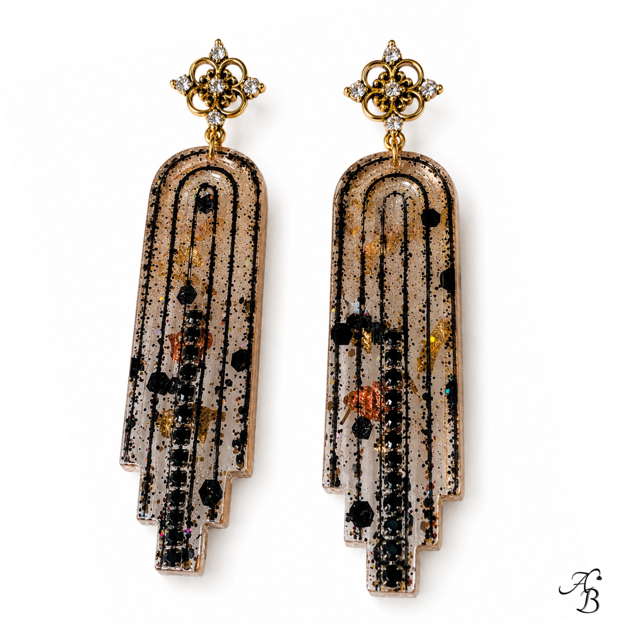 Boucles d’oreilles clous Resin’ Longue dark en résine nervurée avec feuilles métalliques dorées, cuivrées et noires, paillettes dorées et chaînette cristal noir - Aline B Création.